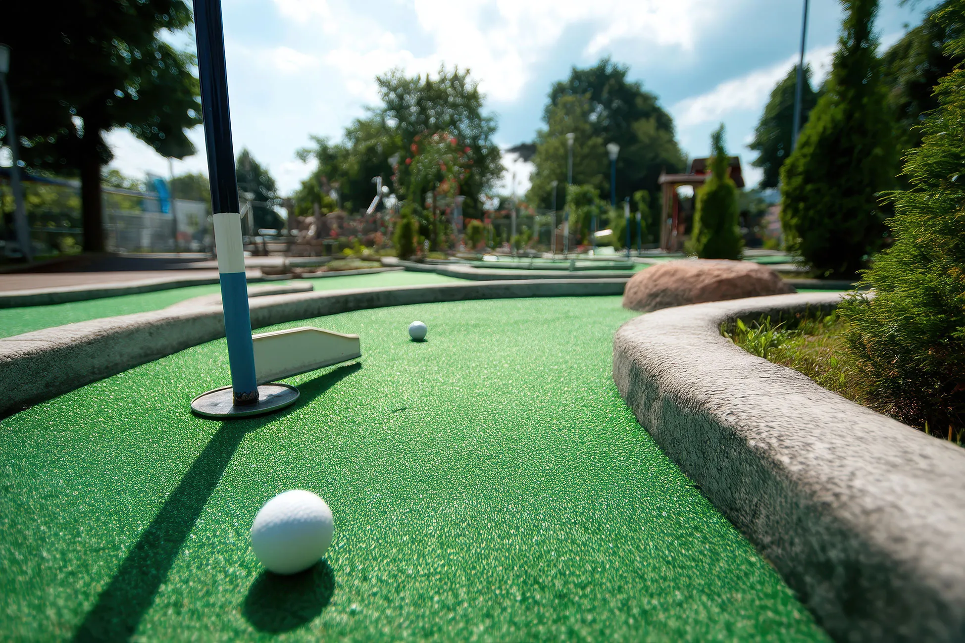 A miniature golf course with a white ball on the green.
