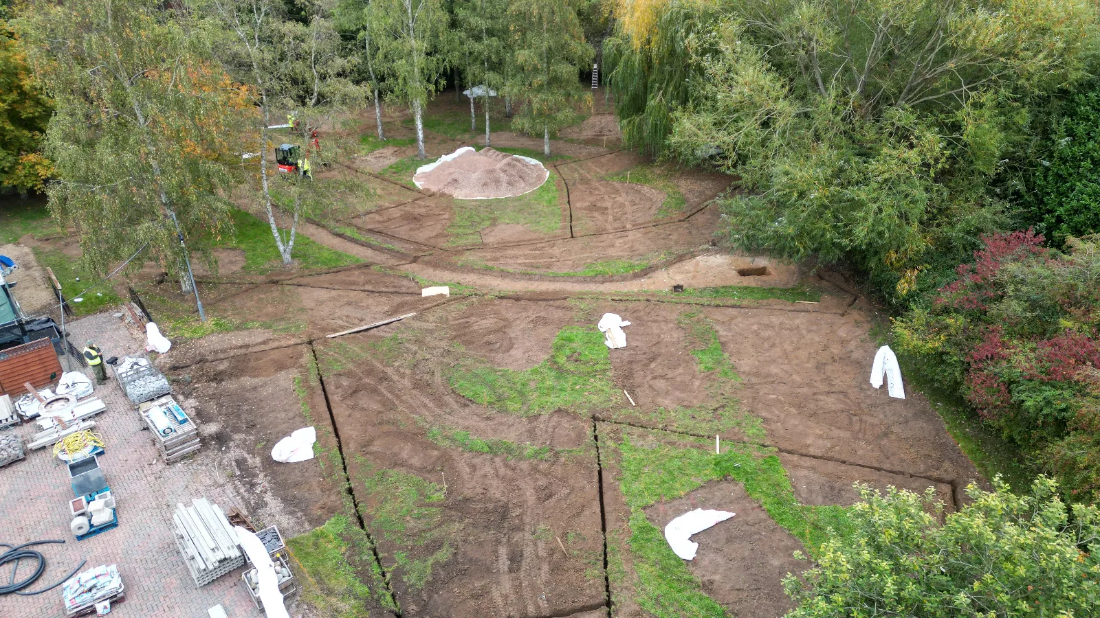 An aerial view of a dirt field with trees in the background.
