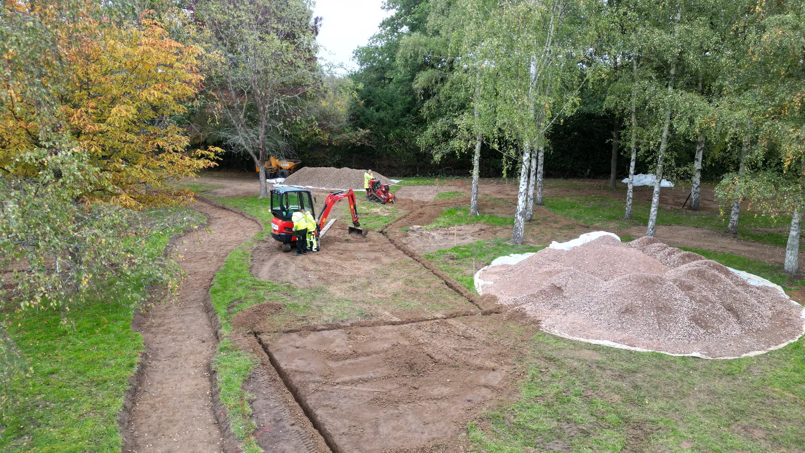 A tractor is parked next to a pile of dirt.