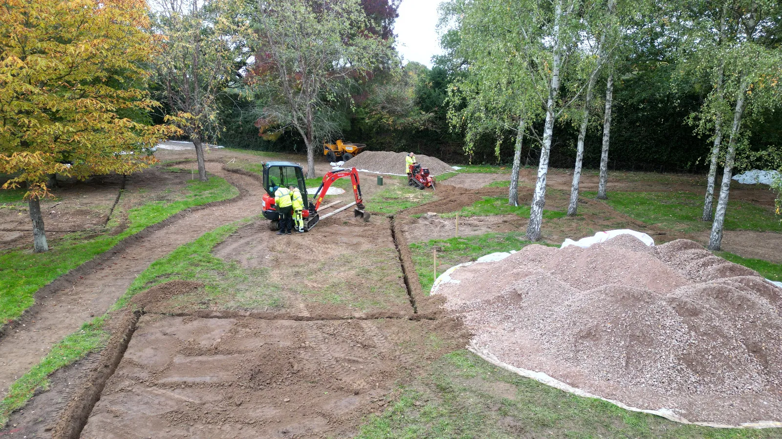 A couple of men working in a dirt field.
