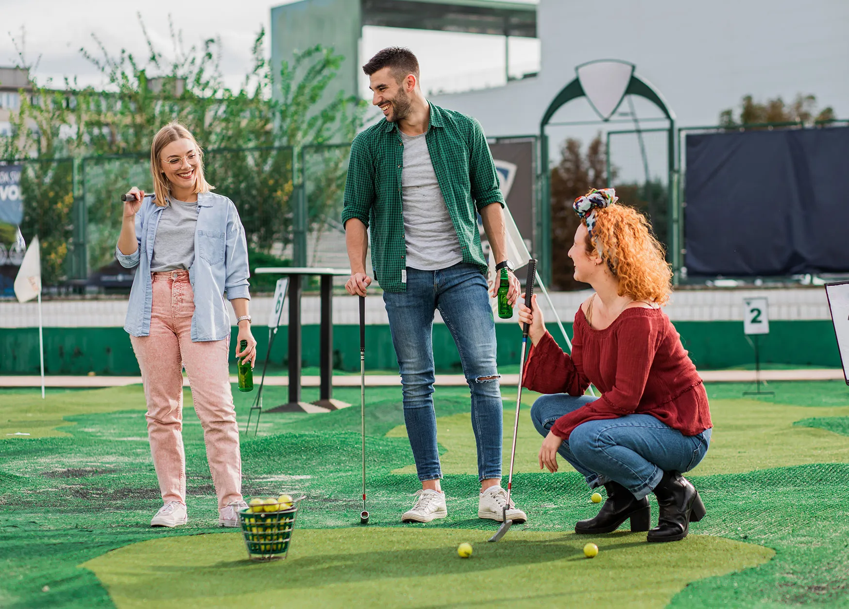 A group of people playing mini golf on a course.